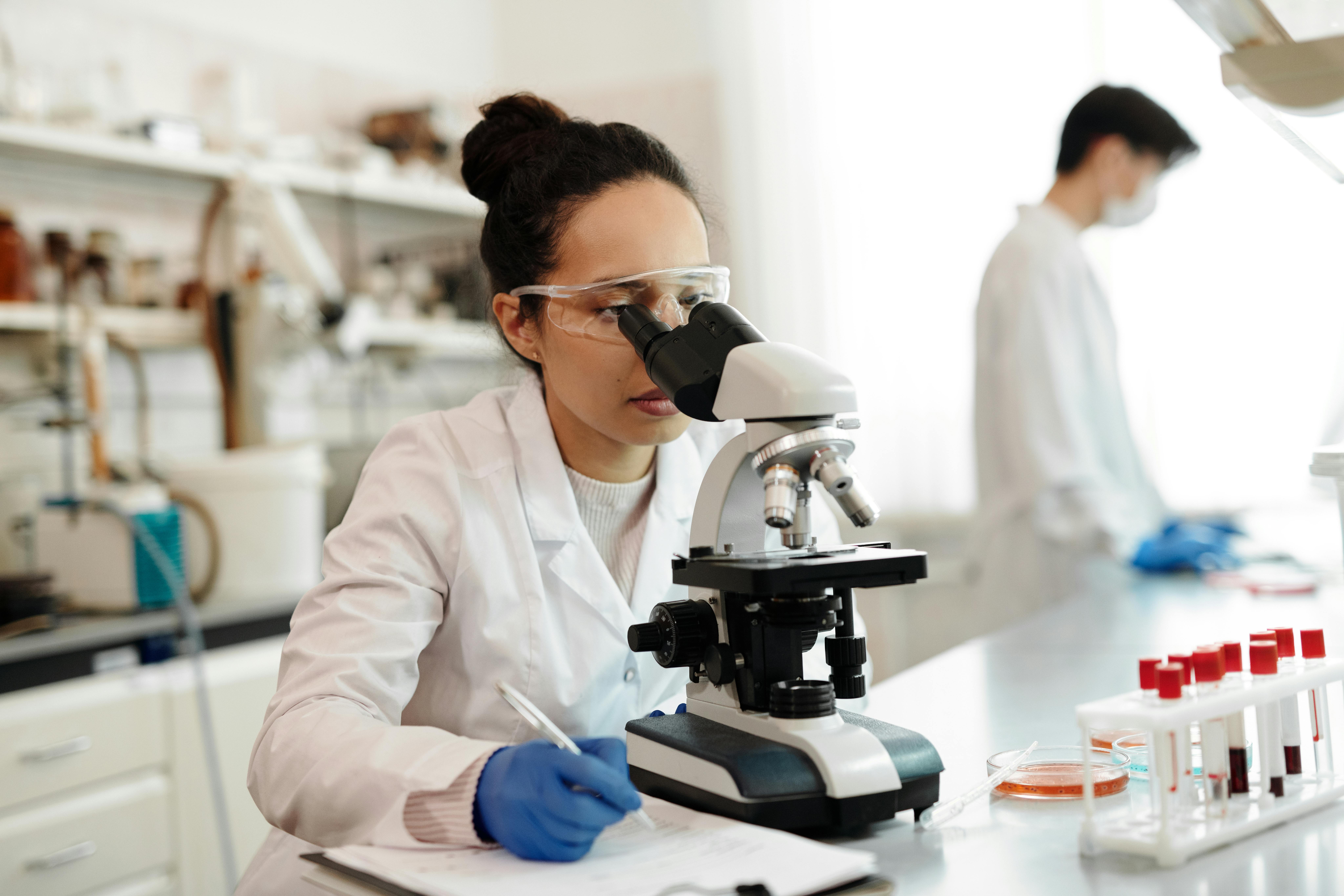 Scientist looking into a microscope in a lab.